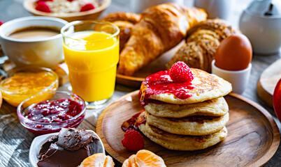 Breakfast served with coffee, orange juice, pancakes, croissant