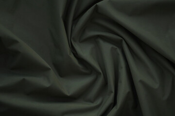 Texture of Dark green military uniform textile cloth with folds