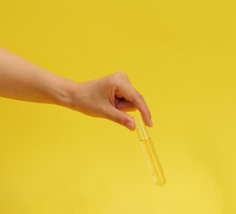 A woman holding an experimental tool and a yellow background