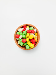 Pilus bintang is a unique Indonesian snack. It has a colorful star shape with a savory and crunchy taste. Served on wooden bowl. Isolated white background
