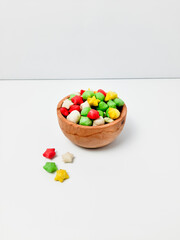 Pilus bintang is a unique Indonesian snack. It has a colorful star shape with a savory and crunchy taste. Served on wooden bowl. Isolated white background