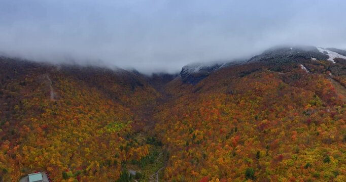 Colorful autumn in the beautiful Vermont, New England, USA. Thick cloudscape covers the mountain tops. Aerial view.