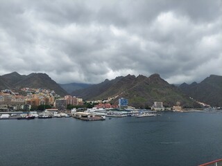 Fototapeta premium SPAIN Santa Cruz de Tenerife APR 22 2024Scenic Coastal City with Mountains and Cloudy Sky