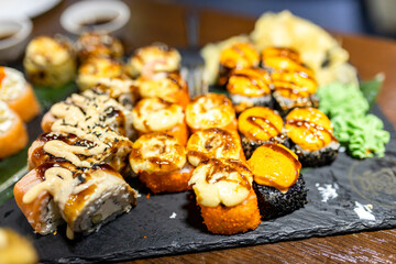 A vibrant sushi platter featuring various rolls with fresh ingredients and garnishes on a wooden table