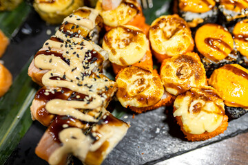 Delicious sushi platter featuring assorted rolls with varying toppings at a vibrant restaurant setting during a bustling evening