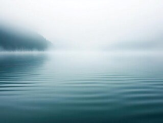 Fototapeta premium serene landscape of a tranquil lake enveloped in morning fog, with gentle ripples on the surface reflecting the soft hues of dawn, evoking peace and stillness