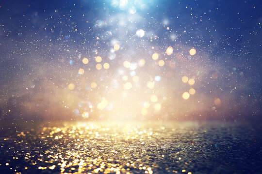 background of abstract glitter lights. blue, gold and black. de focused
