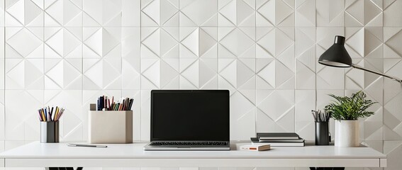Minimalist modern home office desk with a laptop, and stationery on a white table against a wall with patterned wallpaper