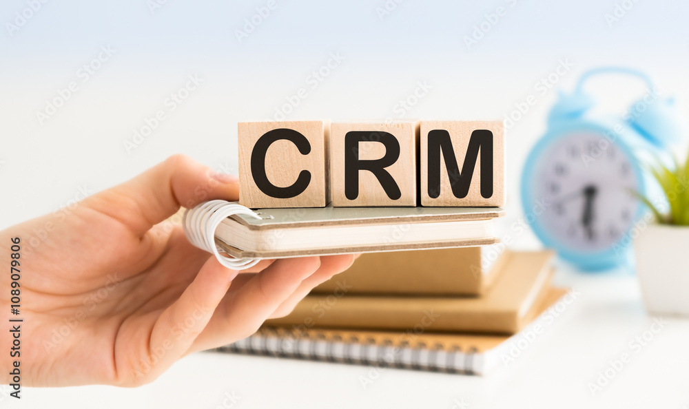 Poster hand holding wood cube block with text crm - customer relationship management. the inscription on th