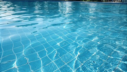 Distorted blue swimming pool water surface with ripples and reflections, poolside, outdoor pool