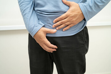 Hernia, Asian man stomach ache, abdominal pain and urology problem health.