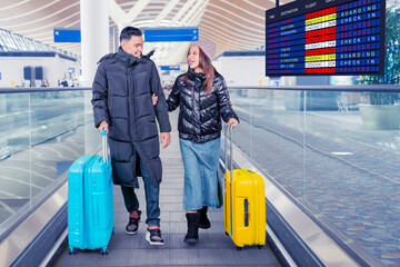 Happy Couple Walking in Airport Terminal with Luggage on Moving Walkway