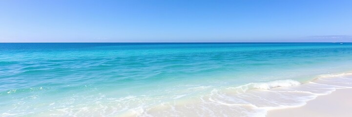 Obraz premium A serene ocean scene with calm turquoise waters and gentle lapping waves against a white sandy beach under a bright blue sky, sunny day, coastal view
