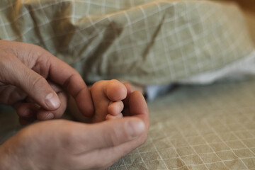 A father wakes up his son by tickling his leg. Gentle morning awakening. Dad and his son Morning...