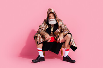 Full size photo of charismatic businessman wear leopard coat hood sit chair isolated on pink color...