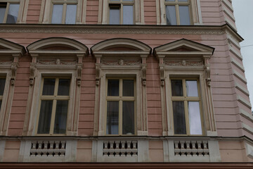 The facade of an elegant and refined historic building showcases beautifully arched windows, intricate ornate detailing, and a captivating charm that reflects its rich architectural heritage