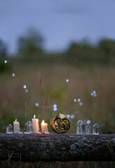 quartz crystals, moon amulet, burning candles outdoor, abstract dark nature background. Witchcraft,...
