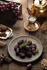 Dates are a typical dessert of Mecca, Medina, served on a black and golden plate and complemented by tea with a golden teapot, symbolizing luxury