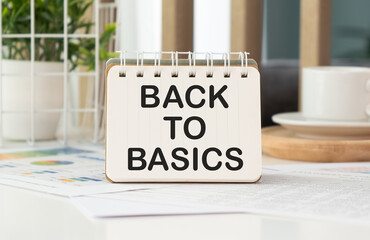 BACK TO BASICS text written on a notebook on table