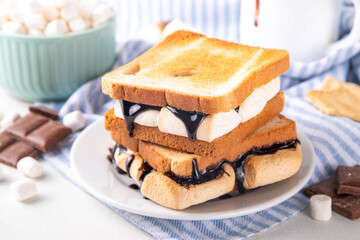 S`mores toasted bread sandwiches with a lot of toasted roasted marshmallow, melted chocolate, Christmas winter tasty breakfast or snack idea, copy space