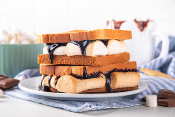 S`mores toasted bread sandwiches with a lot of toasted roasted marshmallow, melted chocolate, Christmas winter tasty breakfast or snack idea, copy space