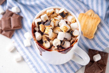 Mug with S`mores hot chocolate or coffee, thick smores hot cocoa or latte drink with toasted marshmallow, graham cracker and chocolate topping