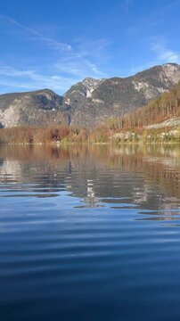 vertical view of lake waters. Fresh air, blue sky along the horizon, mountain skyline, picturesque fishing villages Famous tourist region. Austria