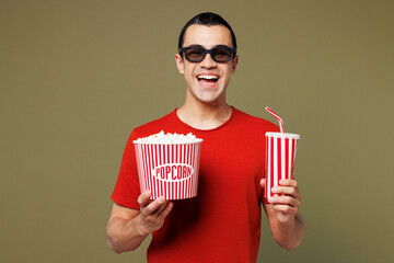 Young middle eastern man he wear red t-shirt casual clothes 3d glasses watch movie film hold bucket...
