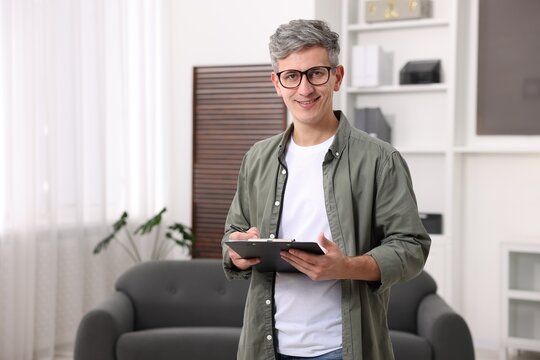 Portrait of professional psychologist with clipboard in office, space for text
