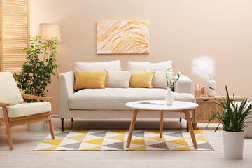 Stylish living room interior with comfortable sofa near beige wall