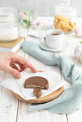Chocolate chip cookies with a cup of tea and a hand. Focus selective