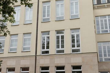 The facade of a contemporary building presents a striking modern aesthetic, featuring multiple windows and unique architectural elements that capture the attention of anyone passing by