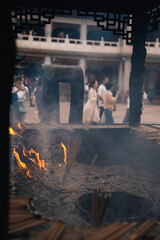 Burning incense with fire and ashes in the Jingan Temple in the center of Shanghai, China