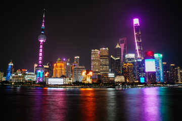 Fototapeta premium Night view of the illuminated skyline of Shanghai from the Bund, with the reflection of the lights in the river; Lujiazui, Shanghai, China