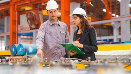 A male expertise engineering is explaining about the quality of metal sheet machine of industry to female inspector and Mechanic or technician in manufacturing or factory, Business's safety check.