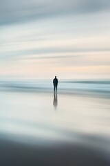Silhouetted person on blurred beach at twilight