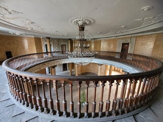 08.12.2023 Tskaltubo, Georgia, second floor of a defunct Soviet-era sanatorium, abandoned building, beautiful glass chandelier, preserved wooden railings, close-up