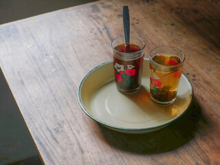 two glasses containing original tea are placed on a tray