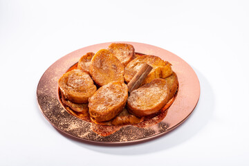 Traditional brazilian christmas Rabanadas with egg yolk crea and cinnamon, Spanish Torrijas on golden plate isolated on white background.