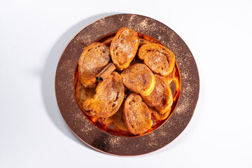 Traditional brazilian christmas Rabanadas with egg yolk crea and cinnamon, Spanish Torrijas on golden plate isolated on white background, top view.