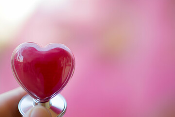 Heart-shaped object on a stethoscope, pink background, healthcare, love, medical, Valentine's Day,  heart health, medical examination.