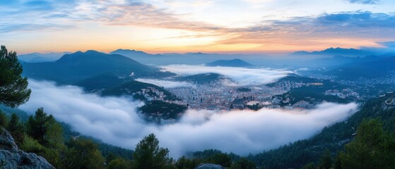 Obraz premium Clouds envelop city skyline at dawn with mountains in background creating a mystical atmosphere