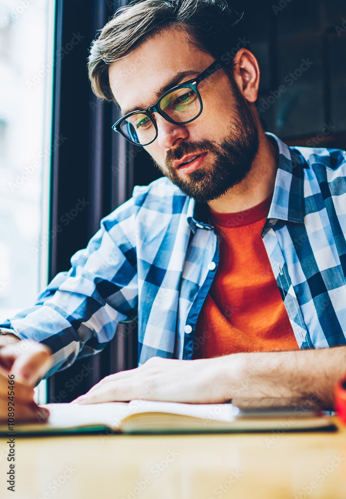 Aufkleber pensive bearded student writing down homework in notepad studying in coworking space.smart hipster g