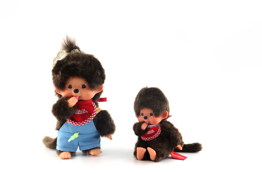 a popular classic doll toy , Monchichi or Monchhichi , Japanese cute monkey fur doll display on white table with white wall background in souvenir tourist shop in Japan