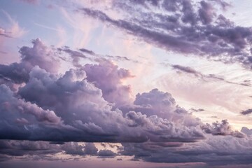 Naklejka premium Cloud formations in shades of mauve and lavender against a pale grey background with subtle texture, mauvelavender, gentlehues, pastelcolors, texturedbackground