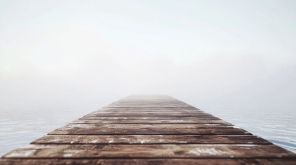 Naklejka premium Foggy dawn scene featuring a wooden dock extending into a misty horizon, creating a serene and minimalist atmosphere with ample negative space.