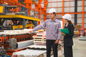 A male expertise engineering is explaining about the quality of metal sheet machine of industry to female inspector and Mechanic or technician in manufacturing or factory, Business's safety check.