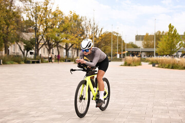 Young athletic woman with helmet riding bicycle outdoors