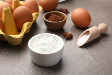 Baking powder, anise stars, eggs and cocoa on grey textured table, closeup
