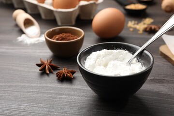 Baking powder and other products on grey wooden table, closeup